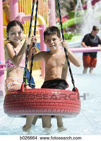Picture - children on a tire swing at a waterpark. Fotosearch