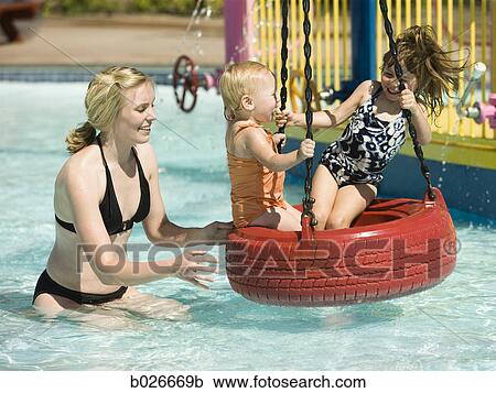 Stock Image - children on a tire swing at a waterpark. Fotosearch
