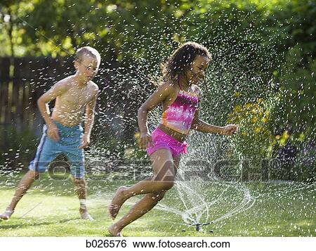 children playing in a sprinkler View Large Photo Image Stock Photograph - children playing in a sprinkler. Fotosearch
