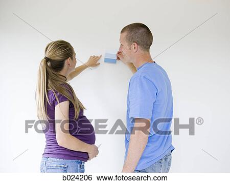Stock Photograph - couple choosing a color to paint a room. Fotosearch