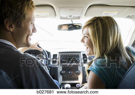 Stock Image - couple driving in the car and laughing. Fotosearch