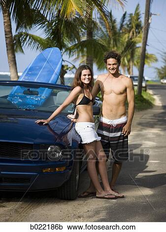 Stock Image - couple going to the beach to surf. Fotosearch