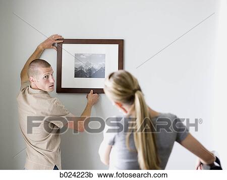 couple hanging a picture View Large Photo Image Stock Image - couple hanging a picture. Fotosearch