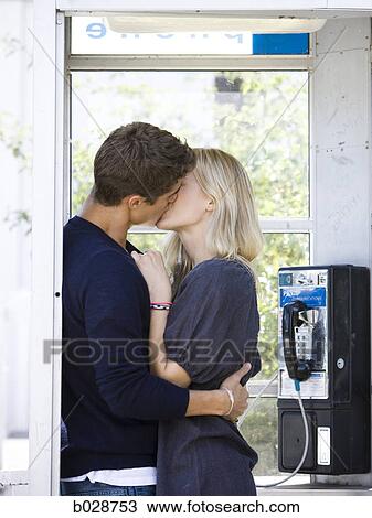 Stock Image - couple kissing in a phone booth. Fotosearch