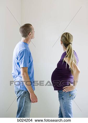 Picture - couple looking at a bare wall. Fotosearch