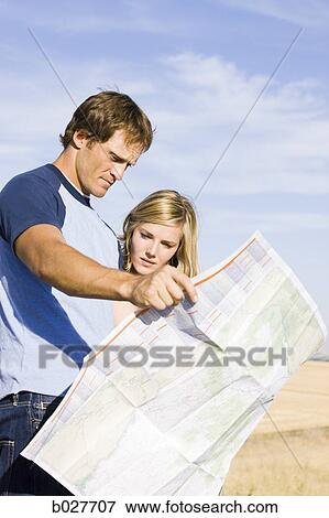 couple looking at a map on the side of the road View Large Photo Image Stock Photo - couple looking at a map on the side of the road. Fotosearch