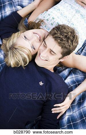 couple lying on a blanket smiling View Large Photo Image Stock Image - couple lying on a blanket smiling. Fotosearch