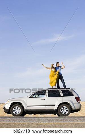 couple on the roof of their car on the side of the road View Large Photo Image Stock Photo - couple on the roof of their car on the side of the road. Fotosearch