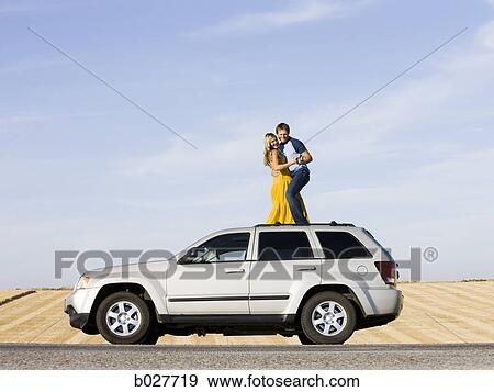 couple on the roof of their car on the side of the road View Large Photo Image Stock Photo - couple on the roof of their car on the side of the road. Fotosearch