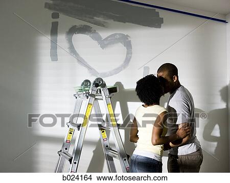 Picture - couple painting a room. Fotosearch