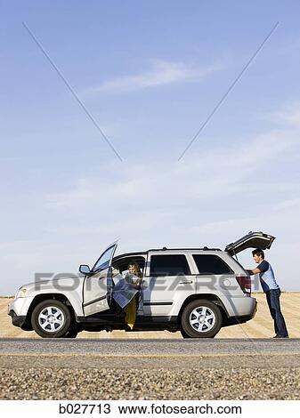 Stock Image - couple pulled over on the side of the road. Fotosearch