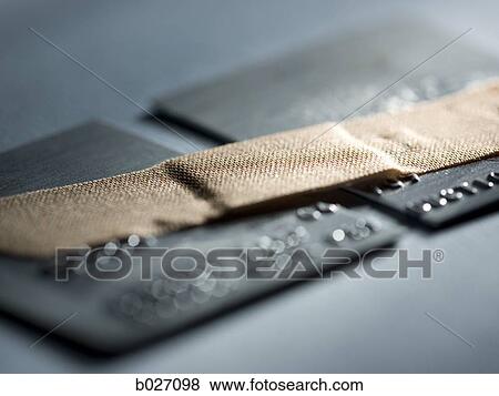 credit card cut in half with a band-aid holding it together View Large Photo Image Stock Photo - credit card cut in half with a band-aid holding it together. Fotosearch