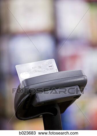 Stock Image - credit card in a point-of-sale machine. Fotosearch