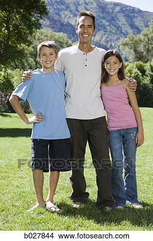 Picture - dad in the park with his two kids. Fotosearch