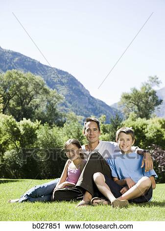 Stock Image - dad in the park with his two kids. Fotosearch