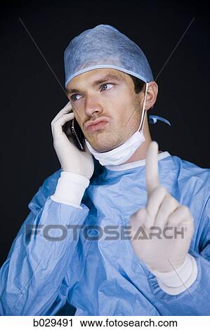 doctor on his cell phone in the middle of a procedure View Large Photo Image Stock Image - doctor on his cell phone in the middle of a procedure. Fotosearch