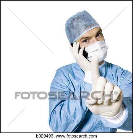 doctor on his cell phone in the middle of a procedure View Large Photo Image Stock Image - doctor on his cell phone in the middle of a procedure. Fotosearch