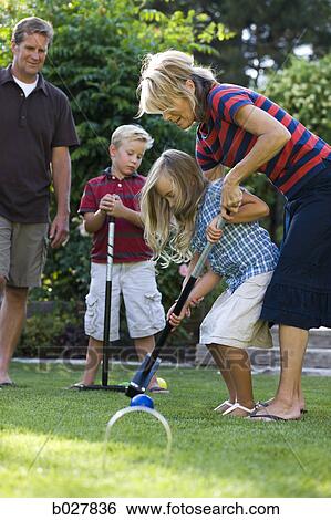 Stock Photograph - family playing croquet in the backyard. Fotosearch