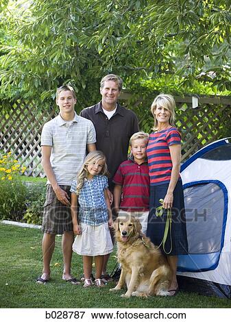 family standing in their backyard with a tent and their dog View Large Photo Image Stock Photo - family standing in their backyard with a tent and their dog. Fotosearch