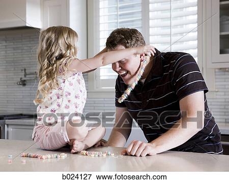 father and daughter making a necklace in the kitchen View Large Photo Image Stock Photo - father and daughter making a necklace in the kitchen. Fotosearch