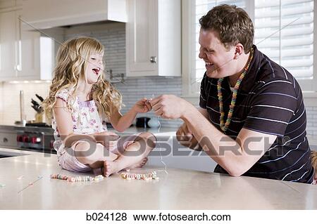 father and daughter making a necklace in the kitchen View Large Photo Image Stock Photo - father and daughter making a necklace in the kitchen. Fotosearch