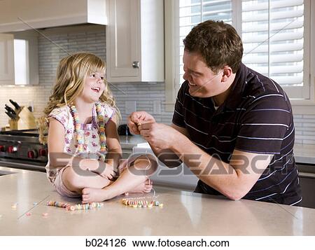 father and daughter making a necklace in the kitchen View Large Photo Image Stock Photograph - father and daughter making a necklace in the kitchen. Fotosearch