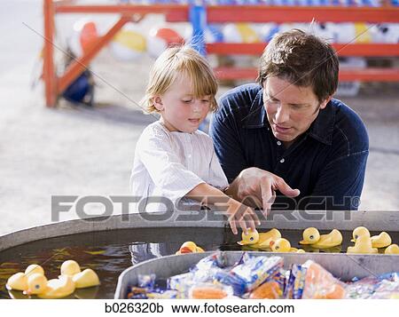 Stock Image - father and son at a carnival. Fotosearch
