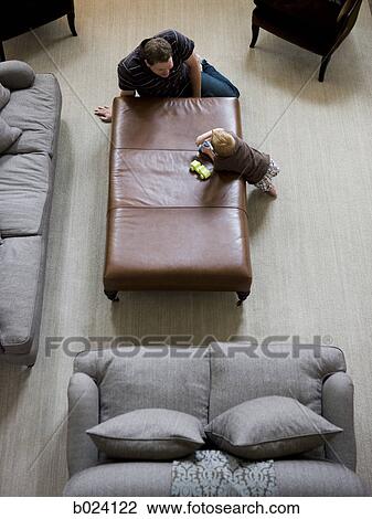 Stock Image - father and son playing in the living room. Fotosearch
