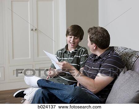 father looking at paper with son View Large Photo Image Stock Photo - father looking at paper with son. Fotosearch