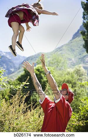 father throwing his daughter in the air View Large Photo Image Picture - father throwing his daughter in the air. Fotosearch
