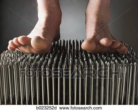 Stock Image - foot walking on nails. Fotosearch