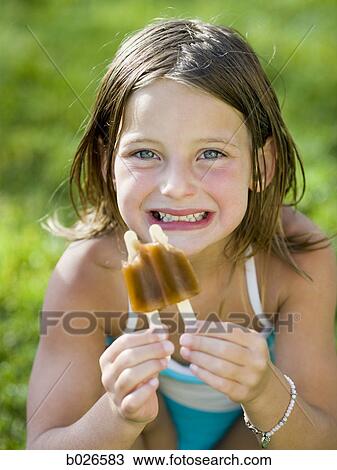 Stock Image - girl eating a popsicle. Fotosearch