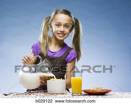 Stock Image - girl eating breakfast. Fotosearch