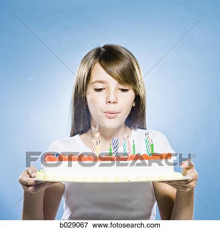 girl holding a birthday cake and blowing out the candles View Large Photo Image Stock Photo - girl holding a birthday cake and blowing out the candles. Fotosearch
