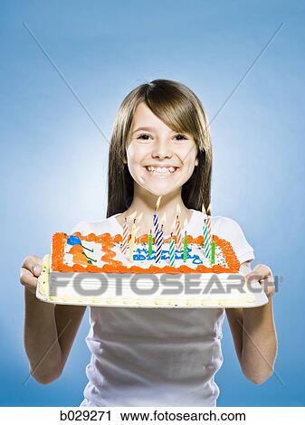 girl looking at the camera holding a birthday cake View Large Photo Image Stock Image - girl looking at the camera holding a birthday cake. Fotosearch