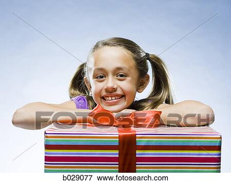 girl looking at the camera resting her head on a present View Large Photo Image Stock Photo - girl looking at the camera resting her head on a present. Fotosearch