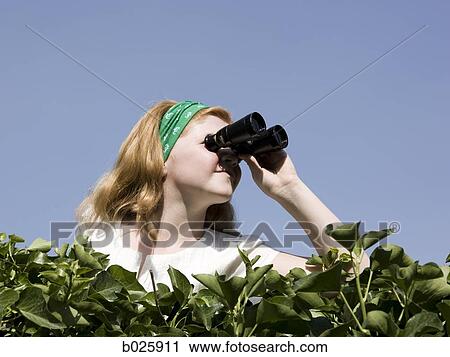 girl looking over a hedge with binoculars View Large Photo Image Stock Image - girl looking over a hedge with binoculars. Fotosearch