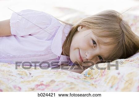 Stock Image - girl lying on a blanket. Fotosearch