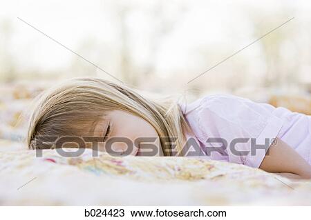girl lying on a blanket View Large Photo Image Stock Image - girl lying on a blanket. Fotosearch