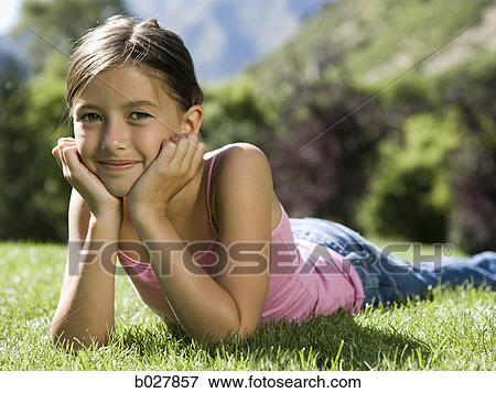 Stock Photo - girl lying on the grass in the park. Fotosearch