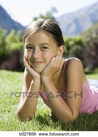 girl lying on the grass in the park View Large Photo Image Stock Photograph - girl lying on the grass in the park. Fotosearch