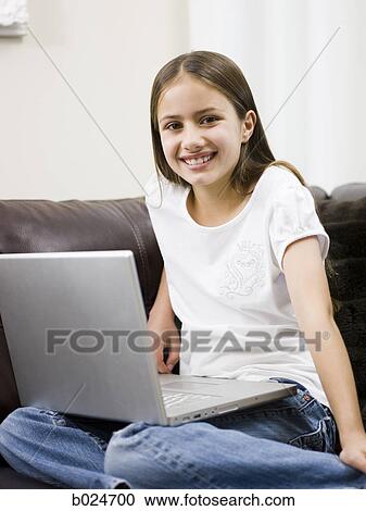 Stock Image - girl on a sofa with a laptop. Fotosearch