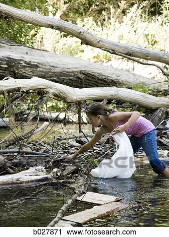 girl picking up trash in a river View Large Photo Image Stock Image - girl picking up trash in a river. Fotosearch