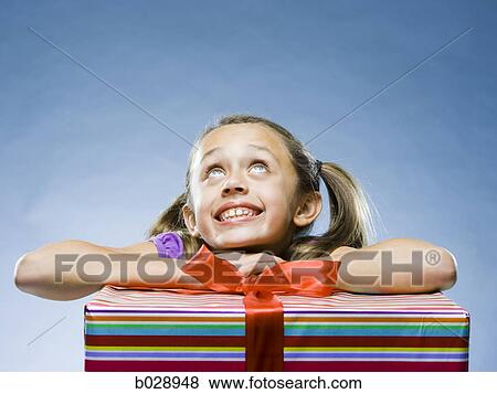 Stock Photo - girl with a present looking up. Fotosearch