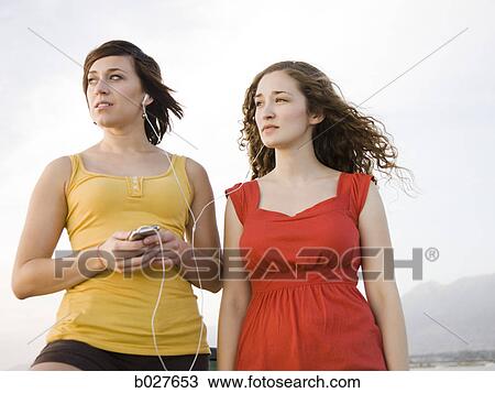 girlfriends sharing an ipod View Large Photo Image Stock Image - girlfriends sharing an ipod. Fotosearch