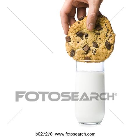 hand attempting to dunk a cookie thats too big into a glass of milk thats too small View Large Photo Image Stock Photo - hand attempting to dunk a cookie thats too big into a glass of milk thats too small. Fotosearch