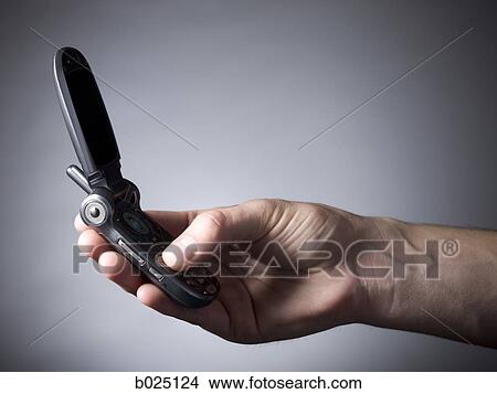 hand holding a cell phone View Large Photo Image Picture - hand holding a cell phone. Fotosearch