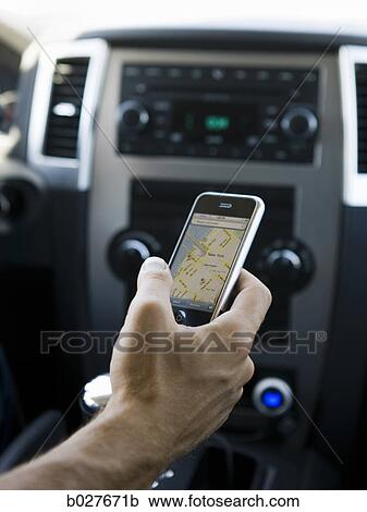 Stock Image - hand holding a cell phone with a map on it. Fotosearch