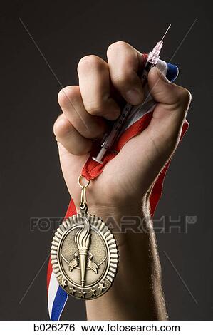 hand holding a gold medal and a syringe View Large Photo Image Stock Photograph - hand holding a gold medal and a syringe. Fotosearch