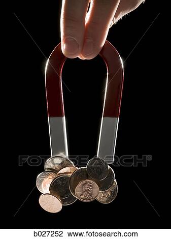 hand holding a magnet with a bunch of coins stuck to it View Large Photo Image Stock Image - hand holding a magnet with a bunch of coins stuck to it. Fotosearch